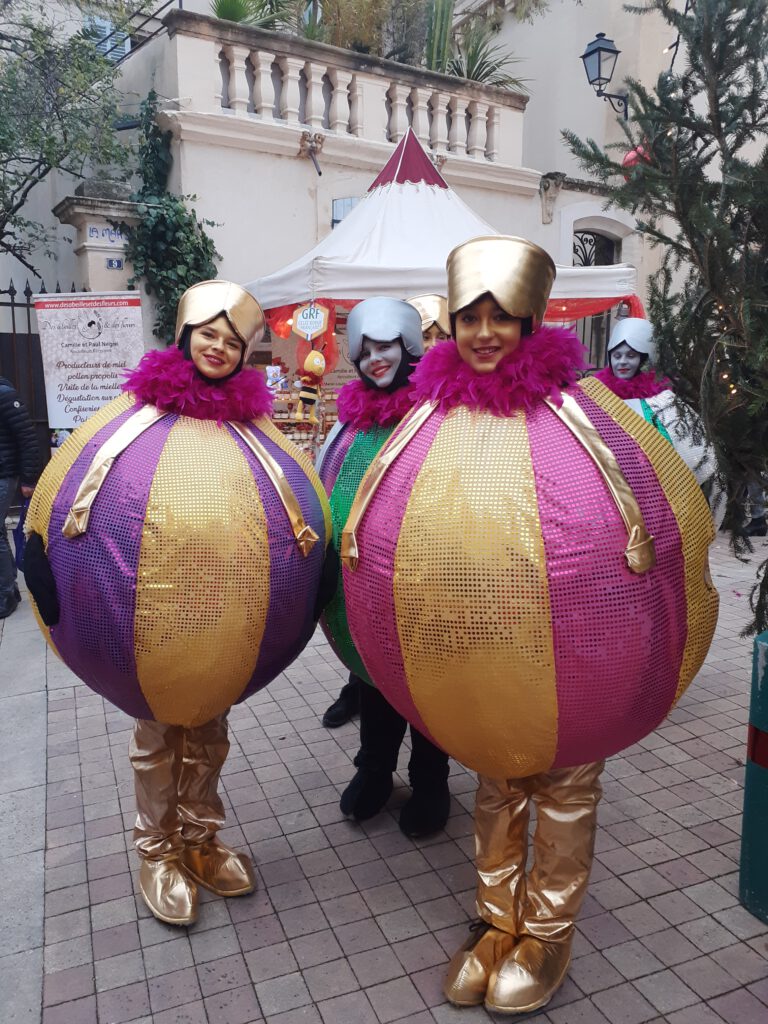 Als Christbaumkugeln  verkleidete Darstellerinnen auf dem Weihnachtsmarkt